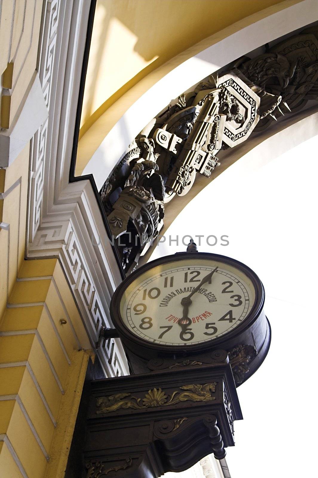 Old-style Public Clocks under the General Army Staff Building Arch in Saint Petersburg, Russia. The inscription on the clock-face: State Chamber for Measuring and Weighing (upper, 19th century designation, now out of use) and Exact Time (bottom).