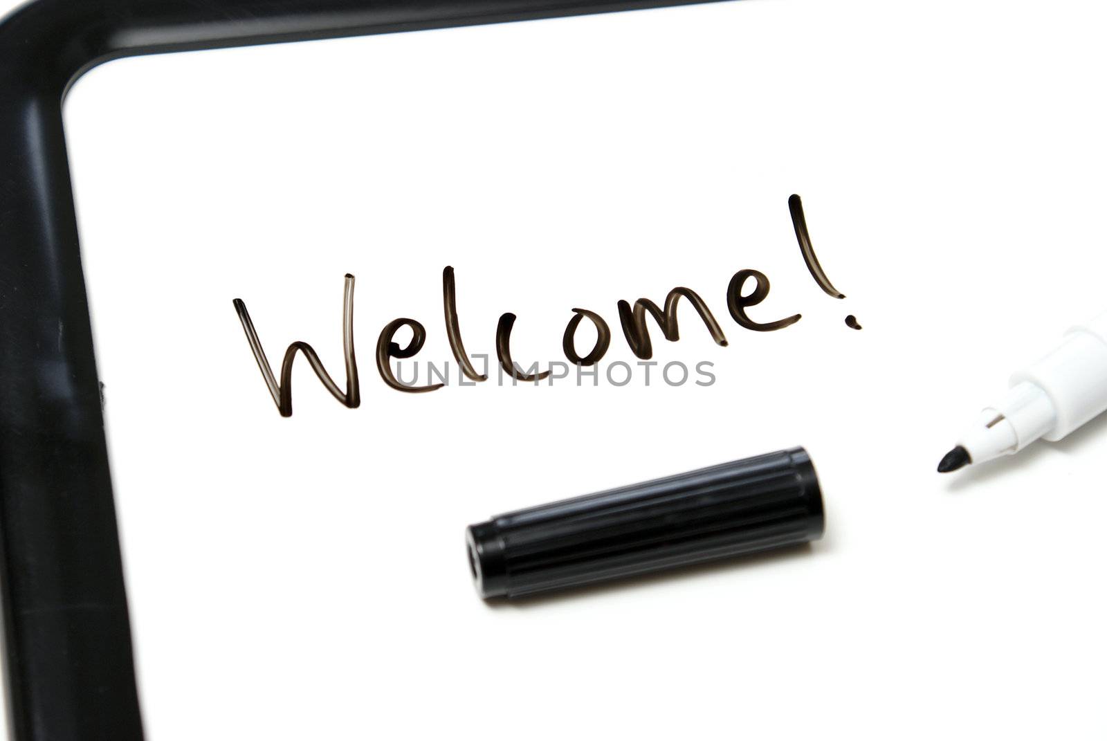 The word welcome is hand written in marker on an office white board.