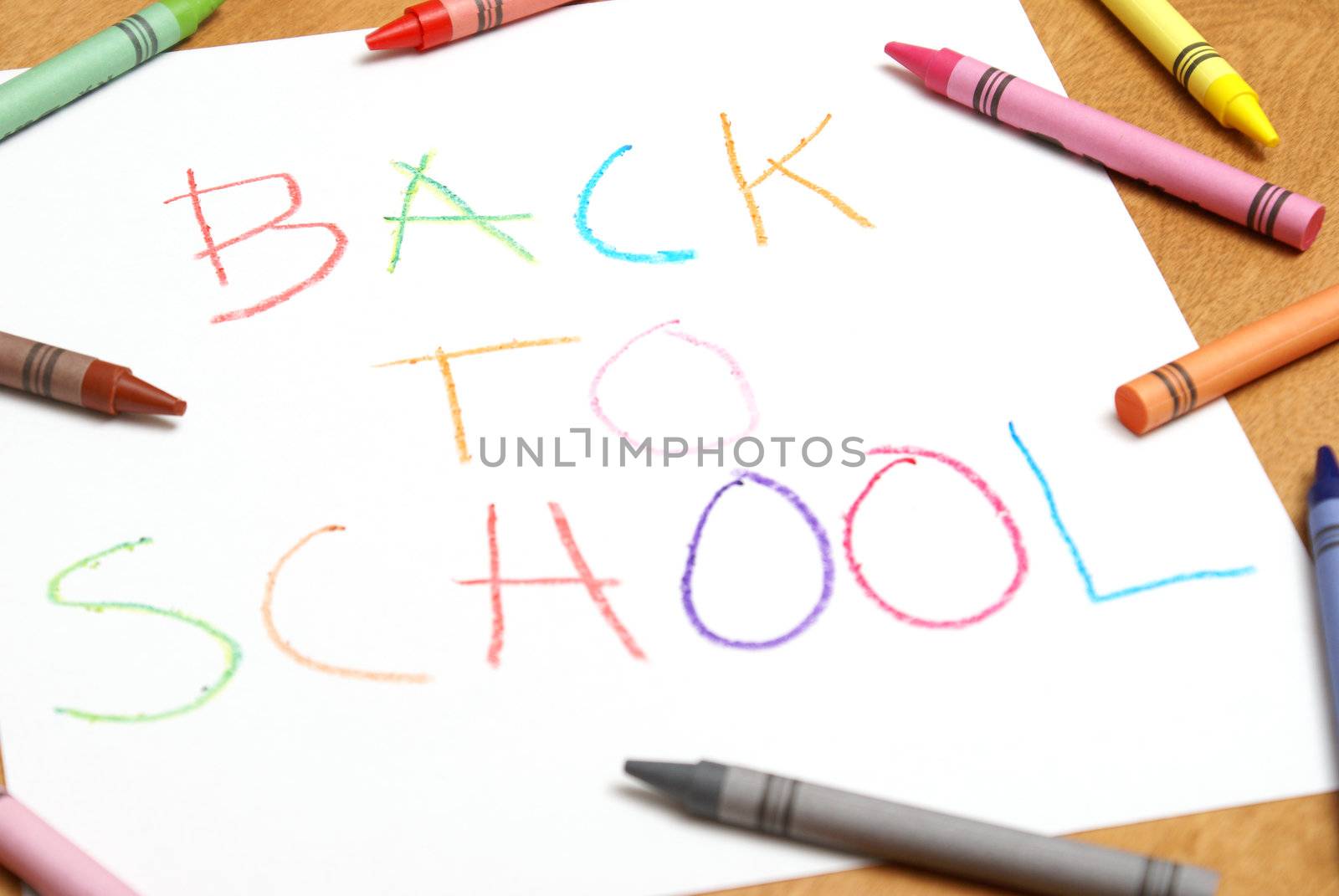 A childish back to school sign written in colorful crayons.