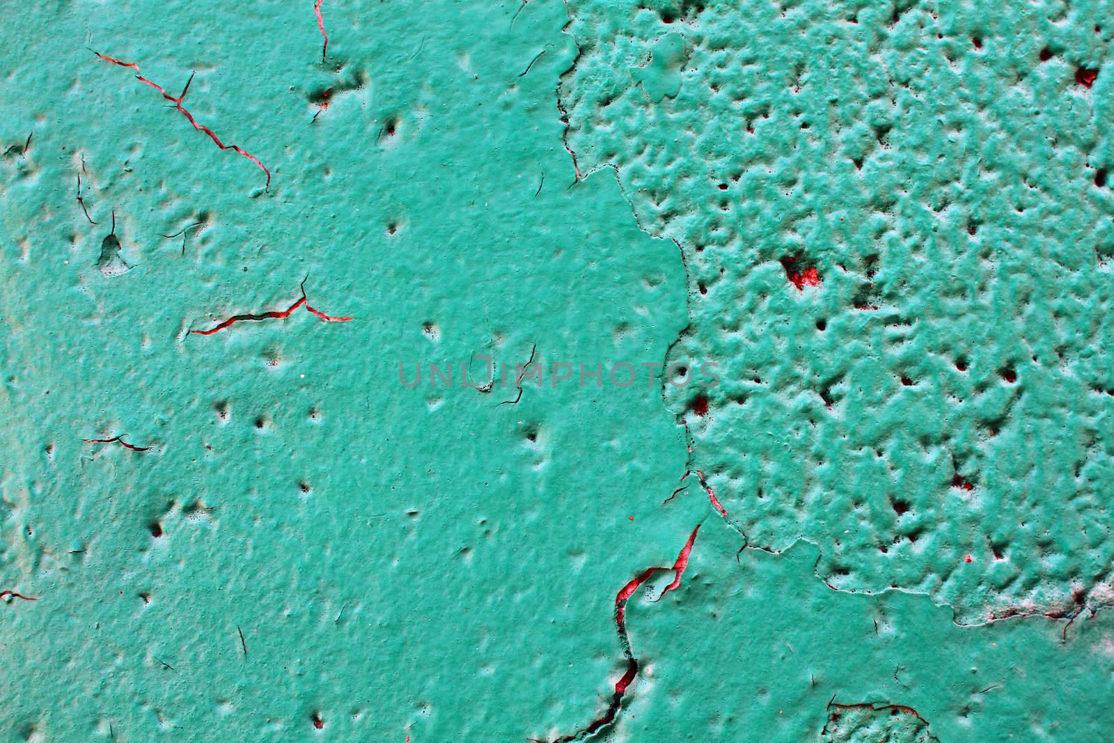 Green concrete wall with cracked and peeling paint.