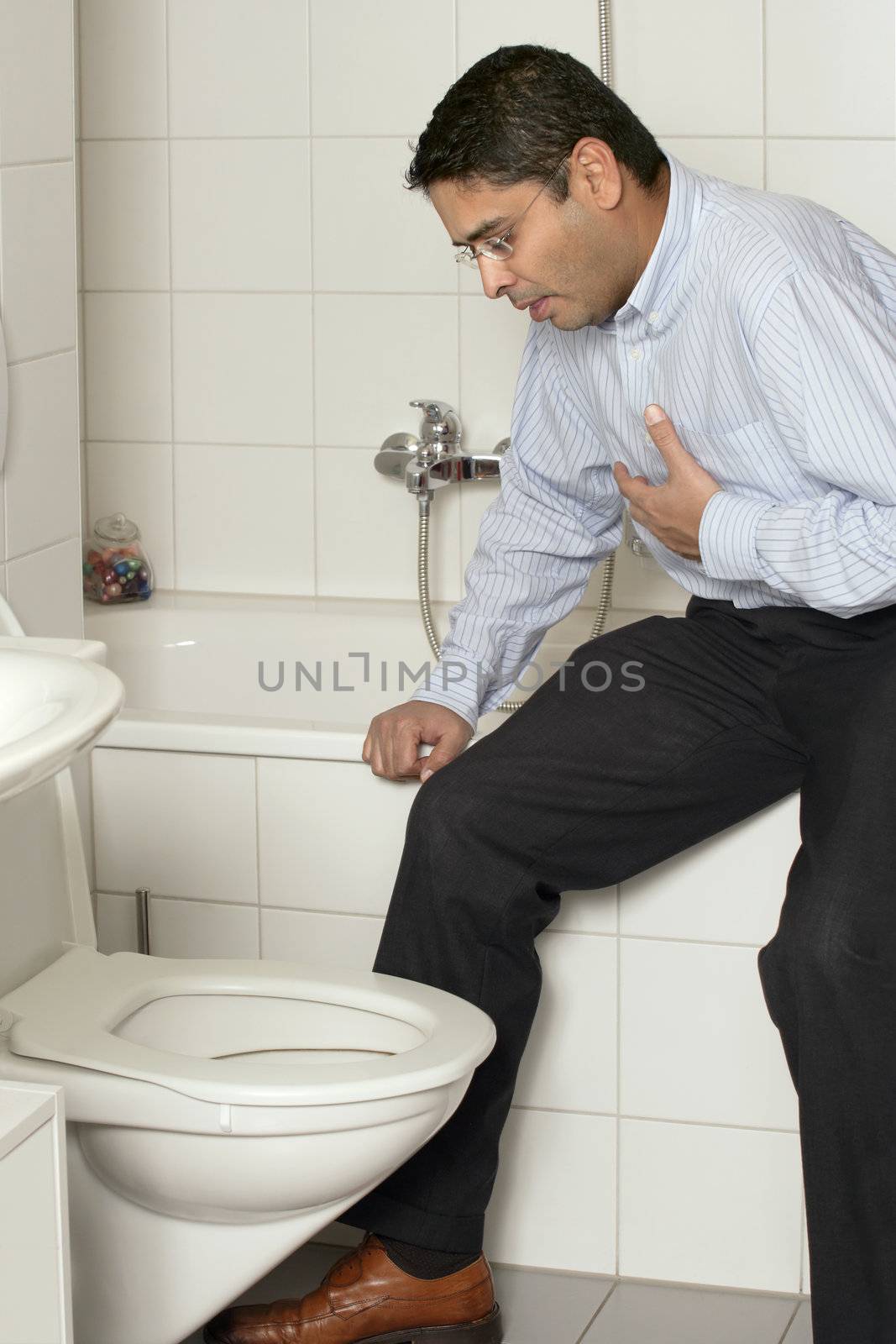 Photo of an adult male in his late thirties with stomach sickness about to vomit into his toilet.