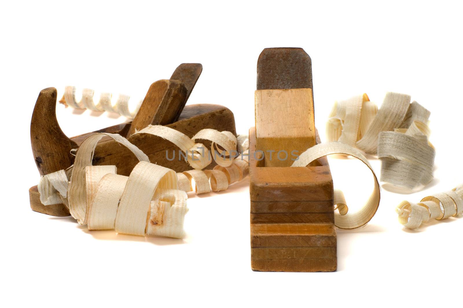 Wood shavings and old planes on a white background.