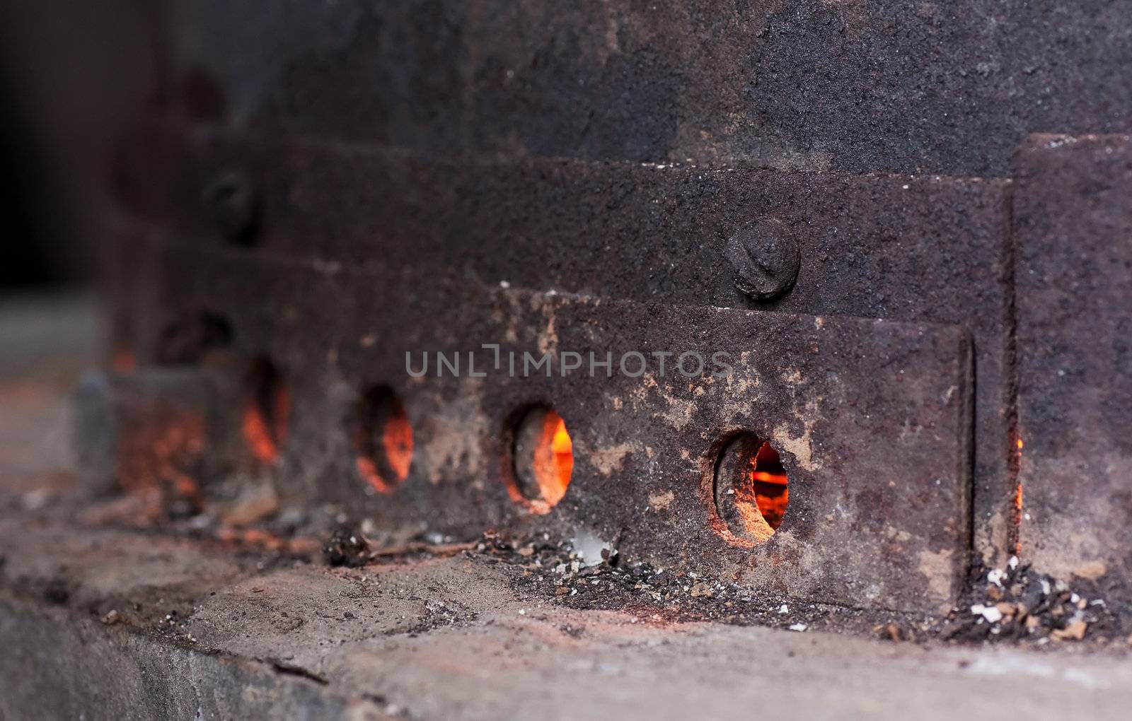 Old rusty coal furnace with hot fire inside