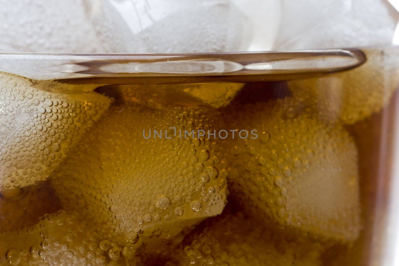 cola soft drink in a glass full of ice cubes