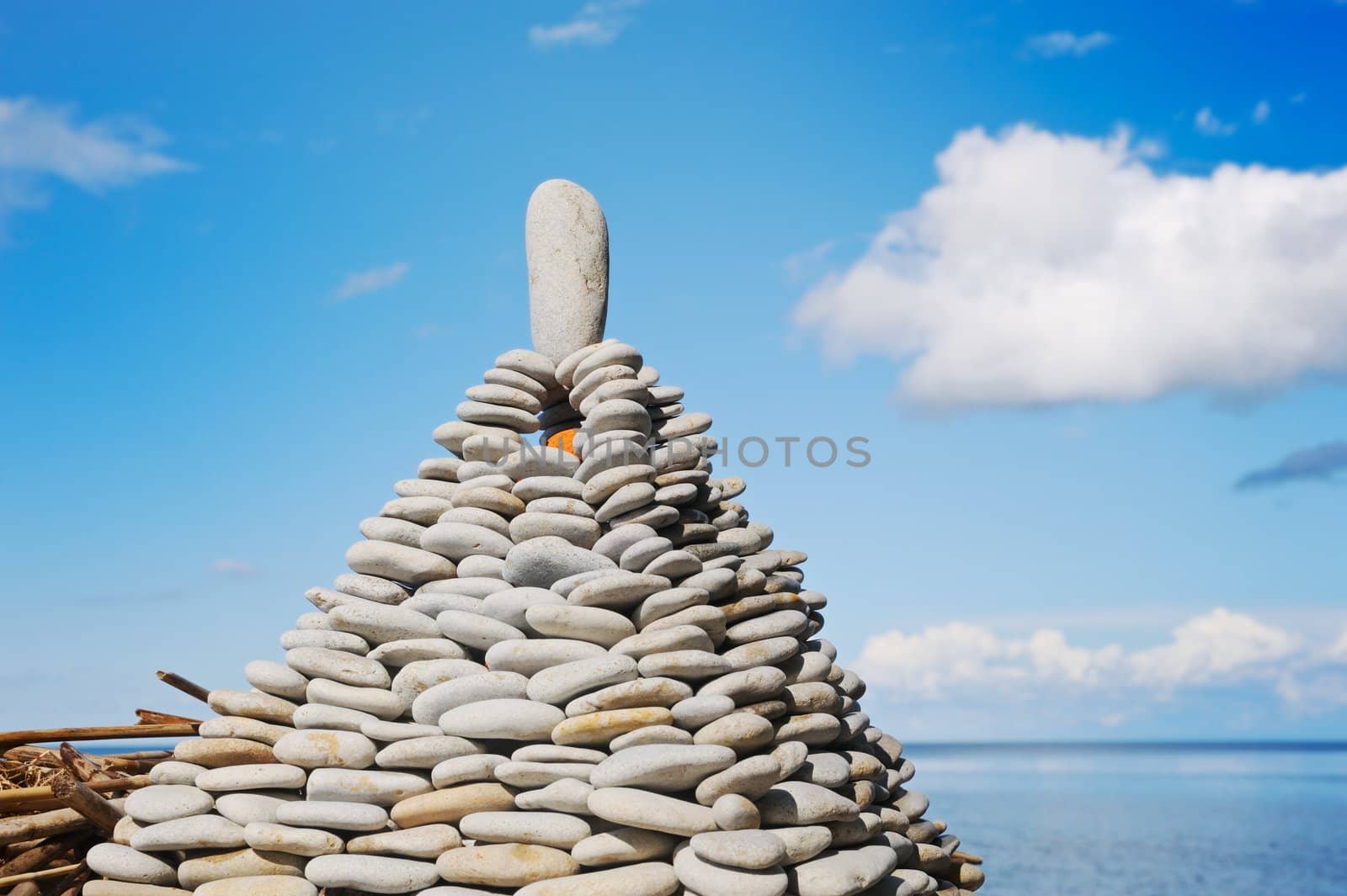 Pyramid from a sea pebble with a stone at top