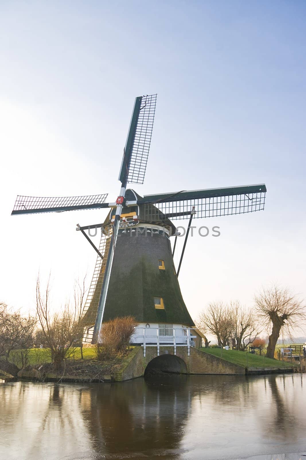 Dutch windmill in frozen winter landscape on a sunny afternoon