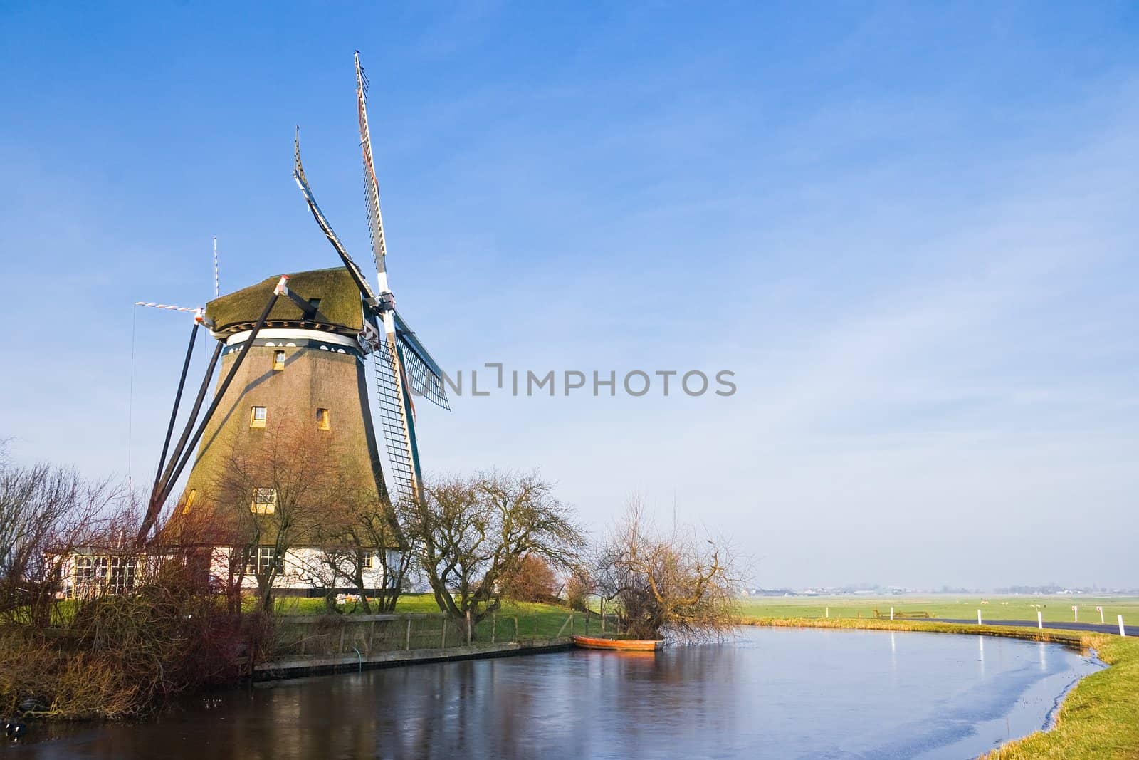 Dutch polder landscape with windmill on sunny winter day