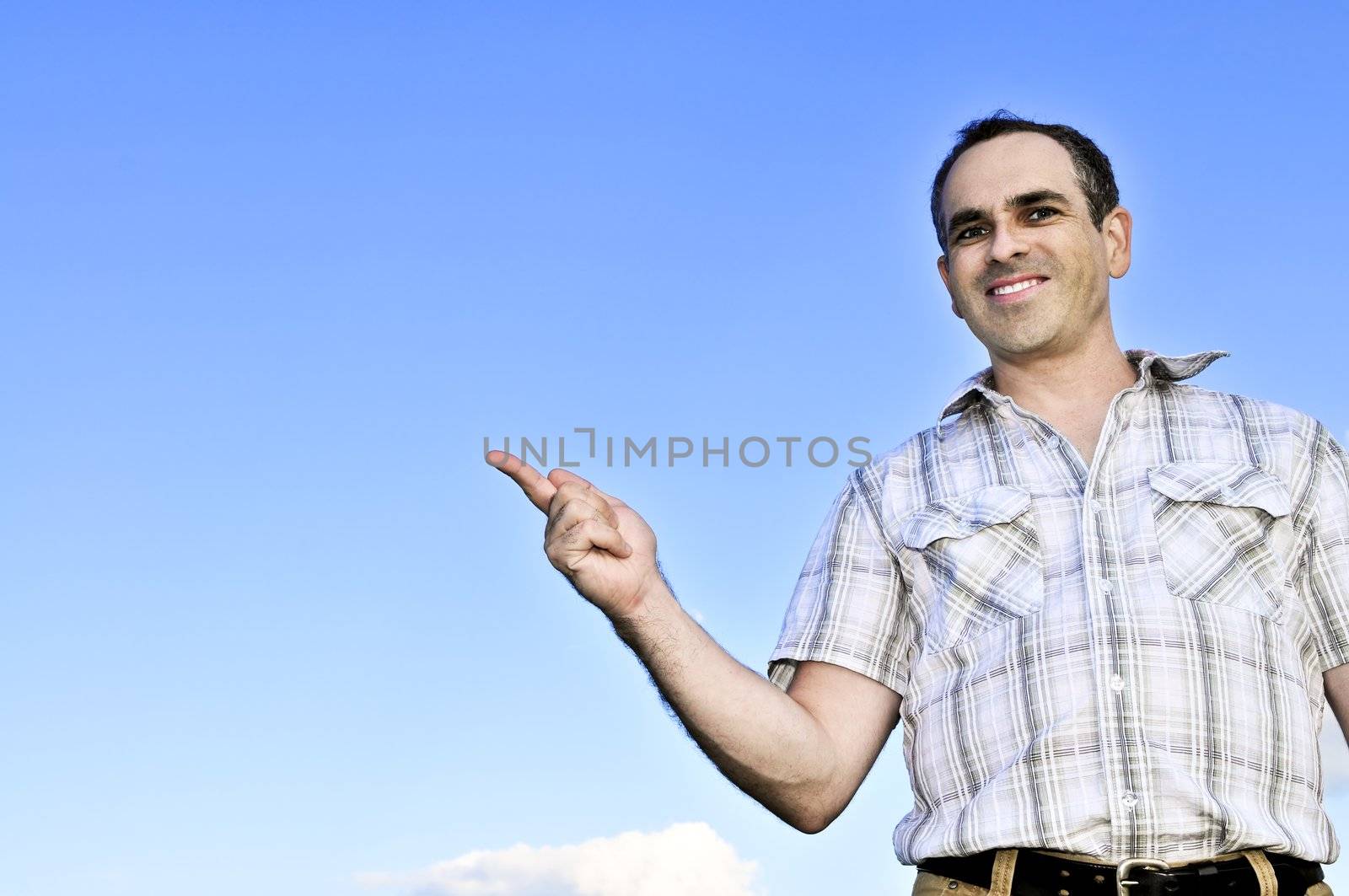Happy middle aged man gesturing on blue sky background