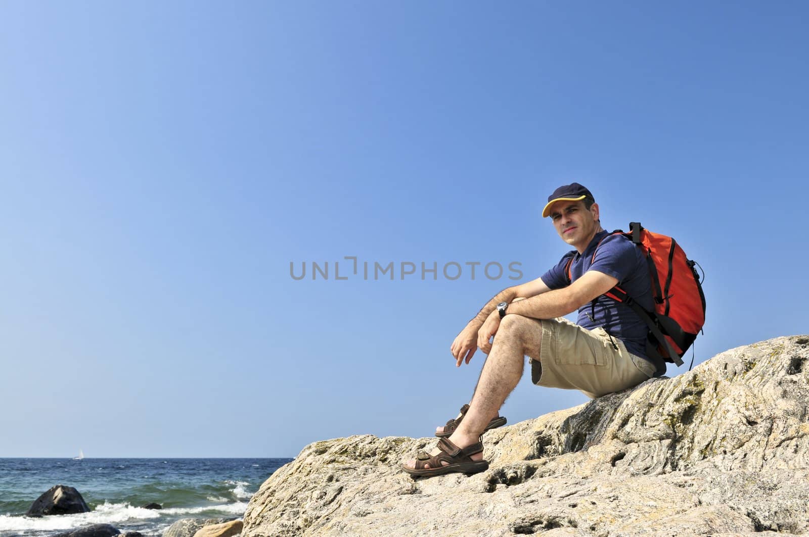 Hiker sitting on a rock by elenathewise