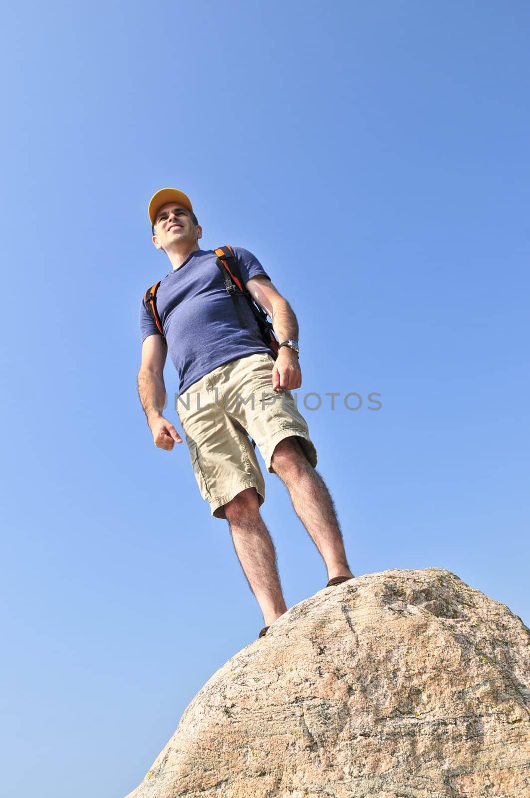 Hiker standing on a rock by elenathewise