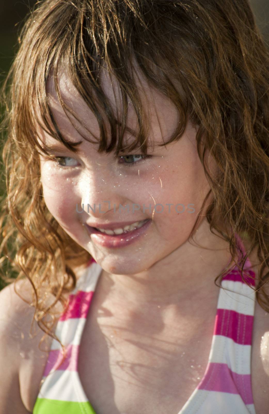 Girl playing outside with water on the summer