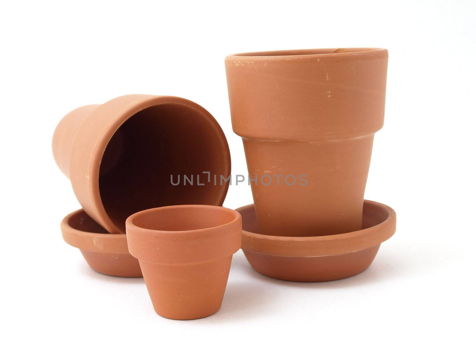 Several different sized terra cotta clay pots isolated on a white background.