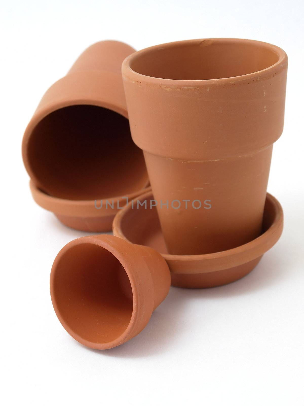 Several different sized terra cotta clay pots isolated on a white background.
