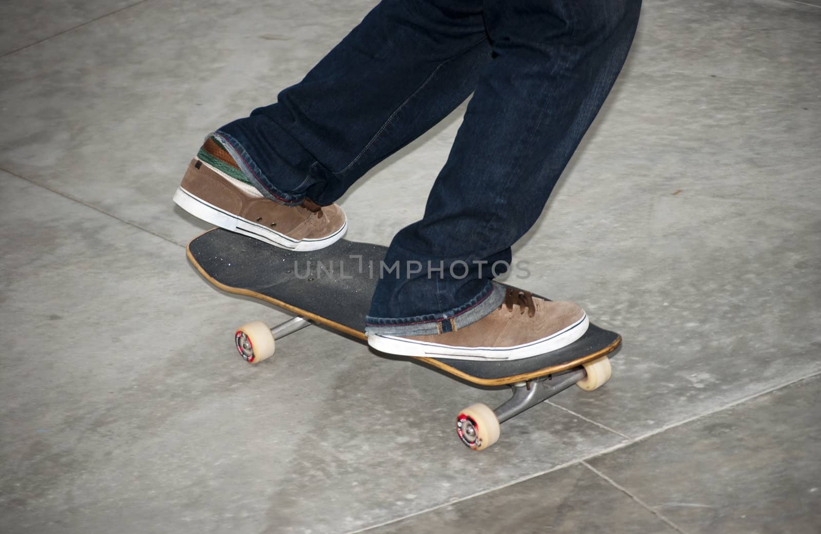 Teenager holding his skateboard at local skatepark