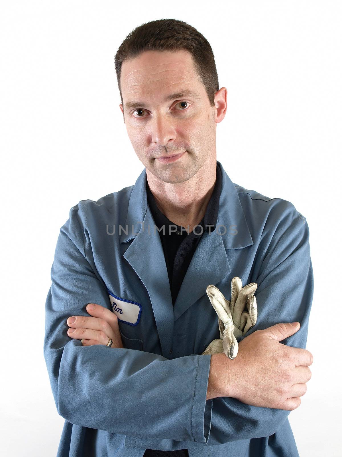 A male employee in a blue lab coat stands with his arms crossed.