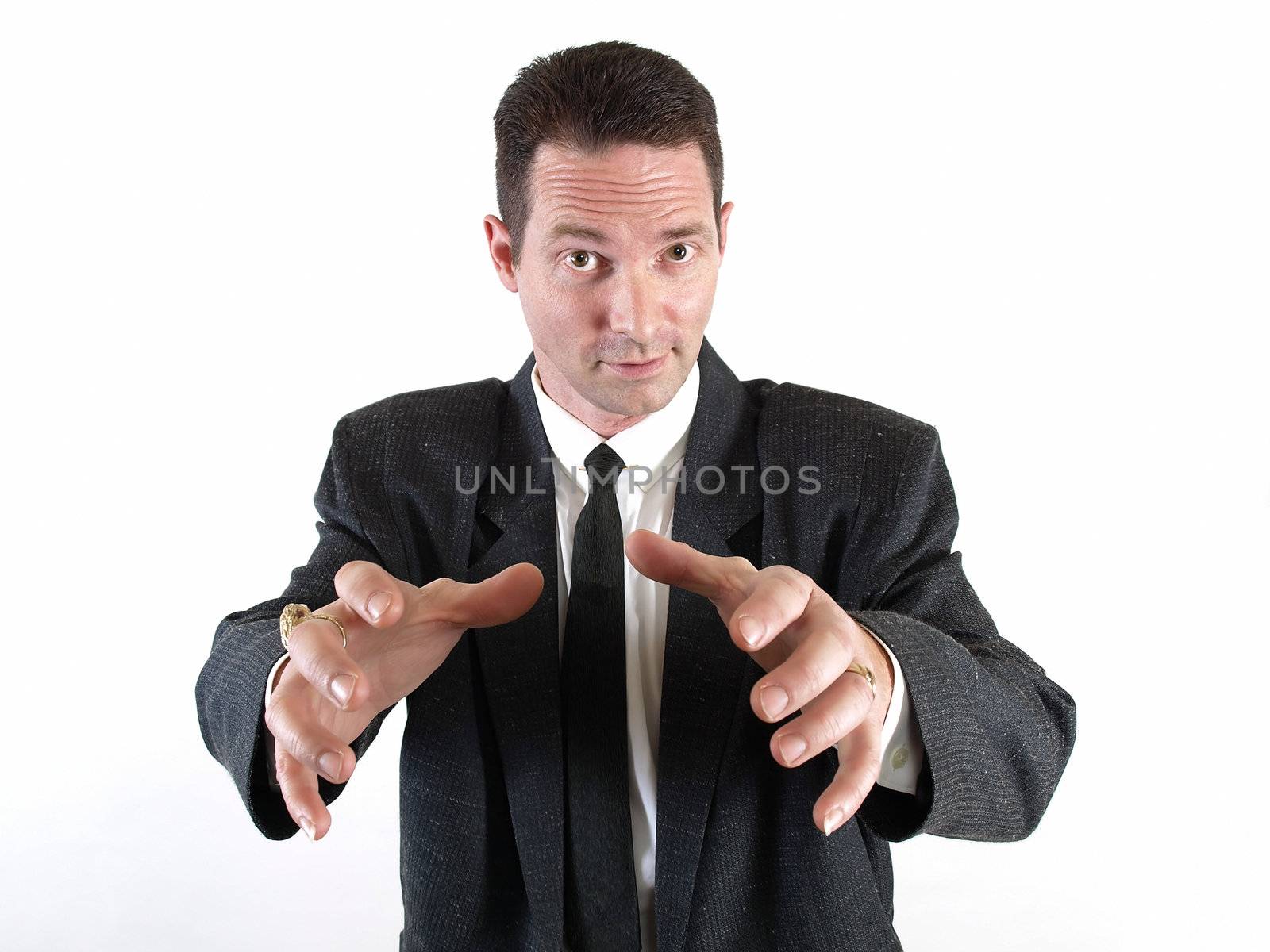 A male in a business suit reaches his hands out ready to grasp something.