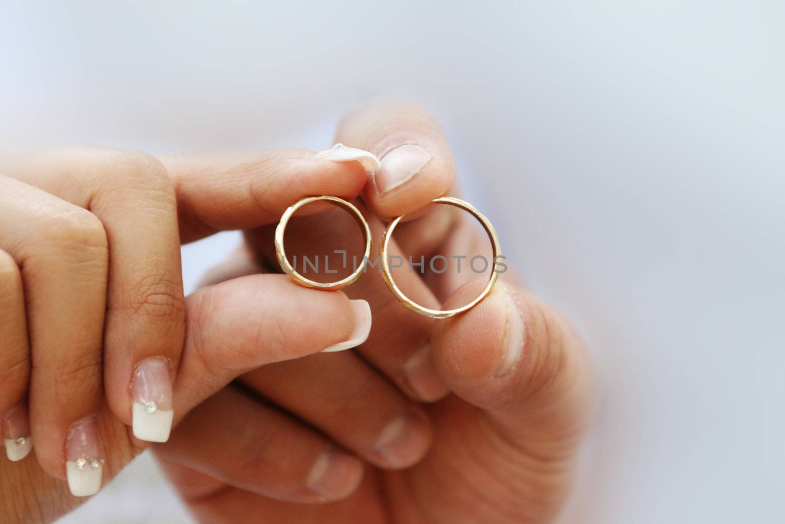 Wedding couple having in their hands beautiful golden rings, symbols of love