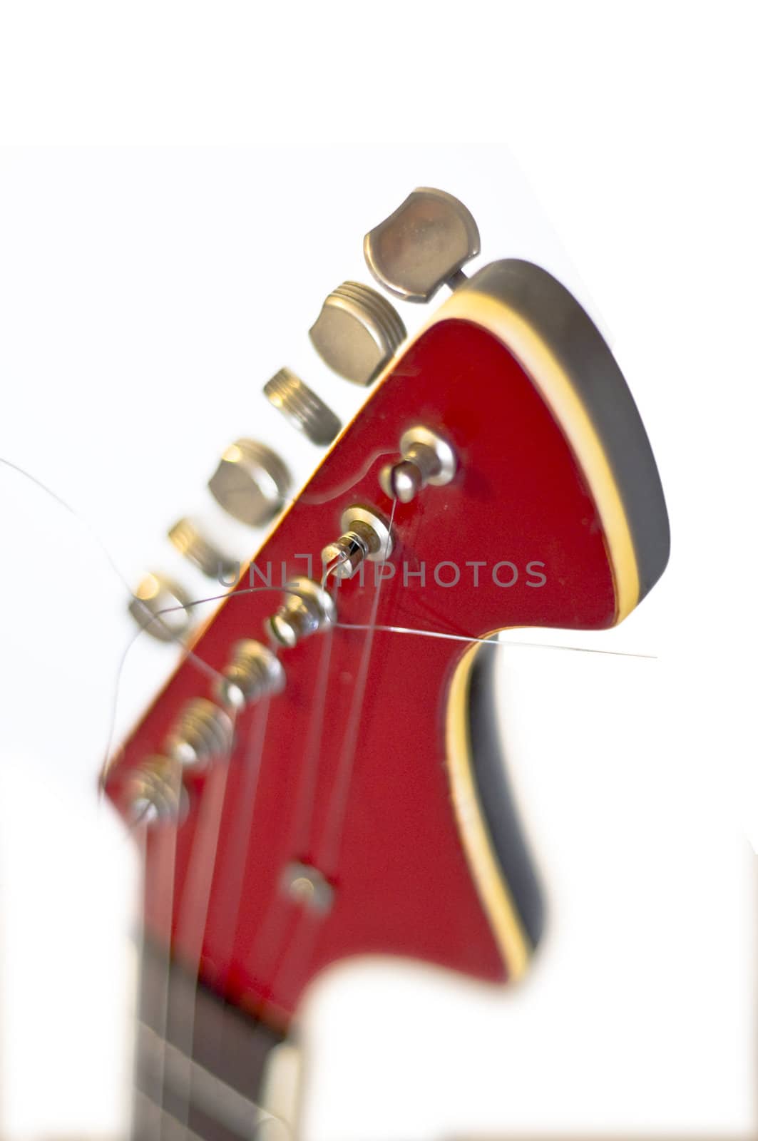 Headstock of an electric guitar close up. On a white background. Selective focus on the string. Blur.