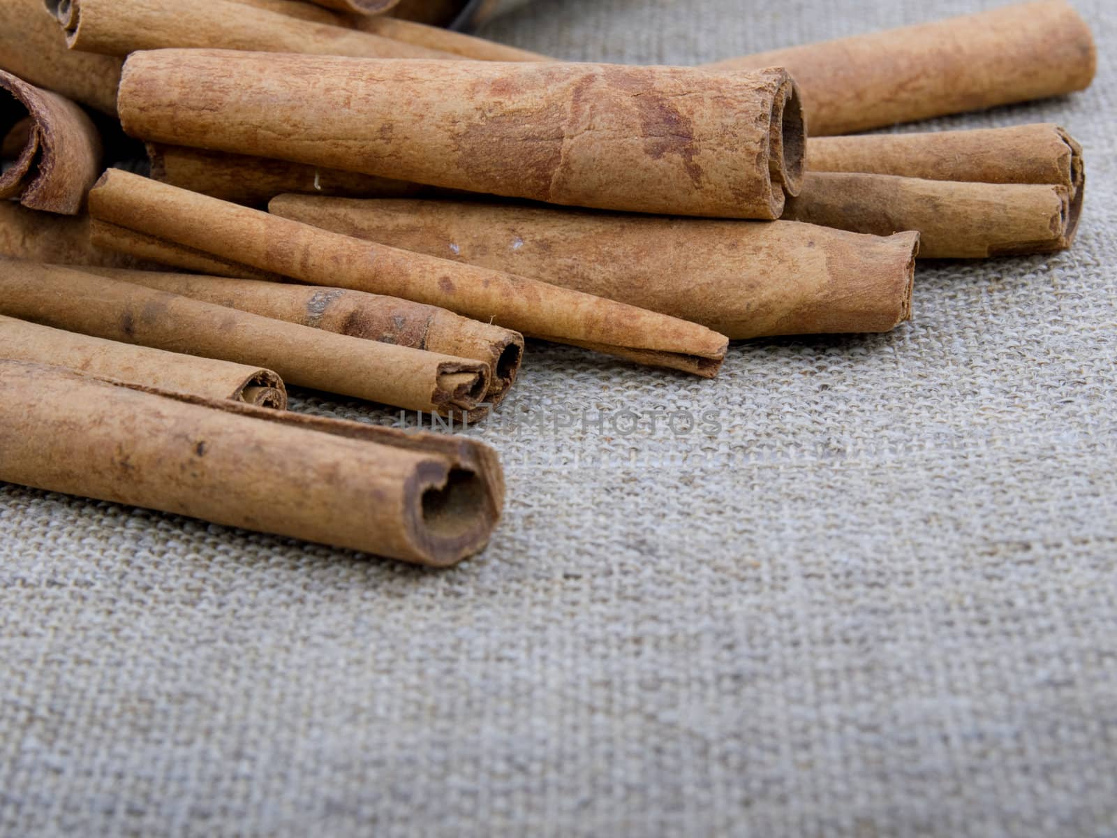 Closeup picture of aromatic cinnamon on linen background