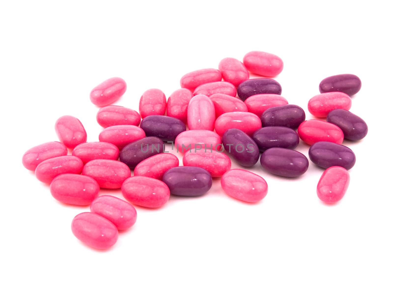 Pink and purple candies on white background