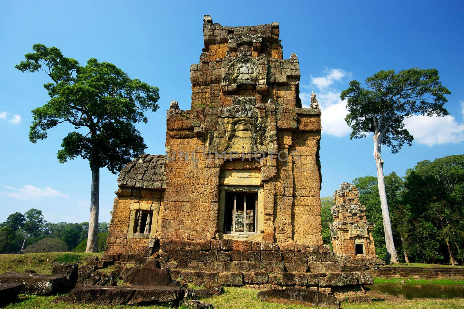 Tower at Angkor Thom, built in the 12th century by king Jayavarman VII, now a crumbling ruin sinking into the marsh. Siem Reap, Cambodia.