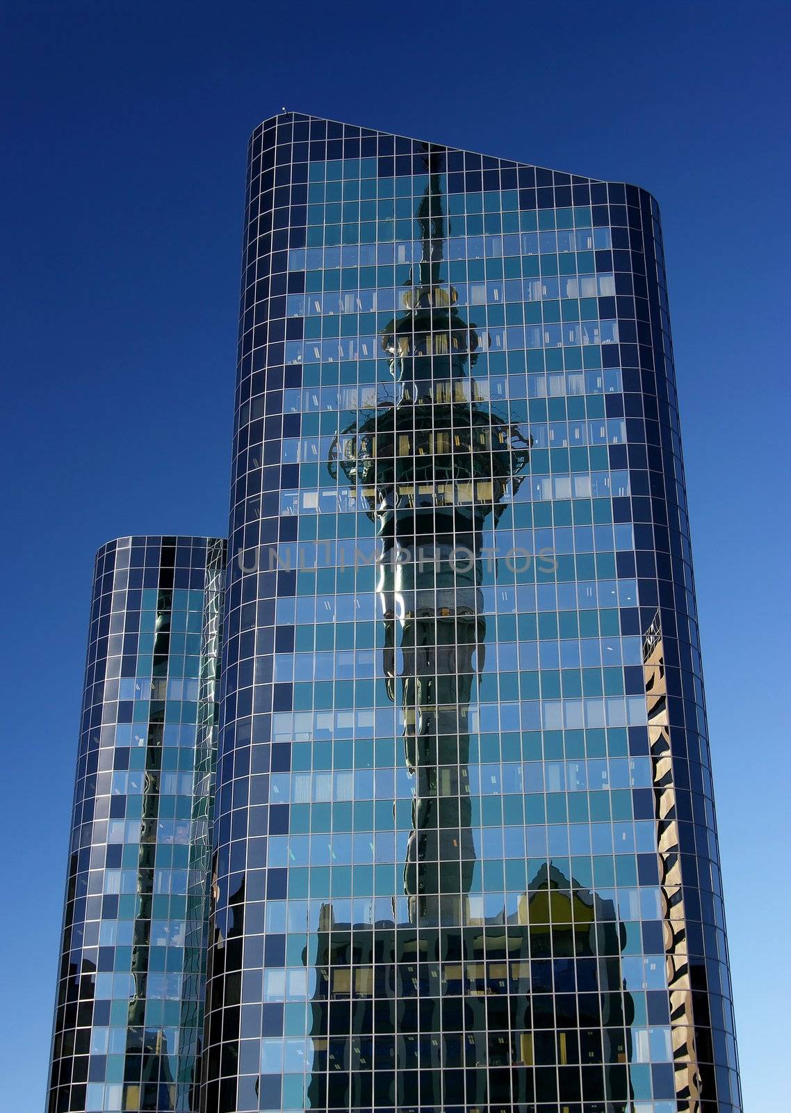 Two high rise office buildings in Auckland City with the Sky Tower reflected in the windows.

