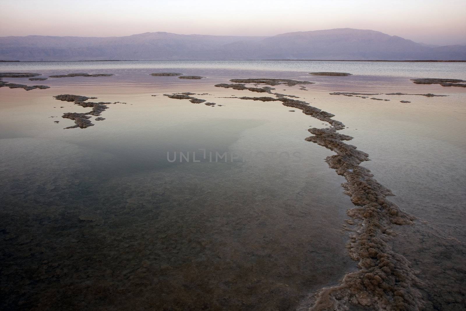 The water of the dead sea with the Jordan mountains at sunset