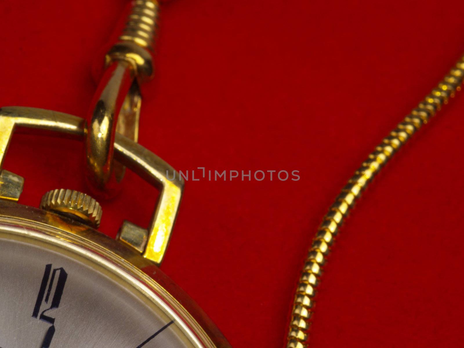 detail of gold pocket watch on red velvet