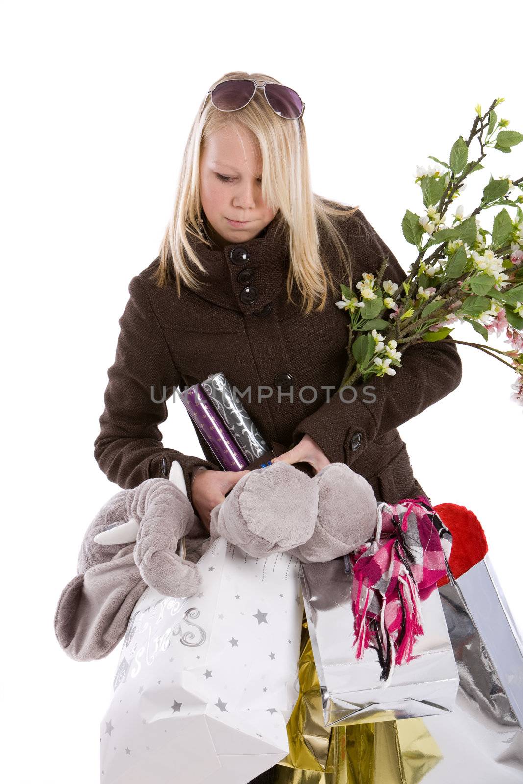 Cute young teenager struggling with her shopping bags on white background