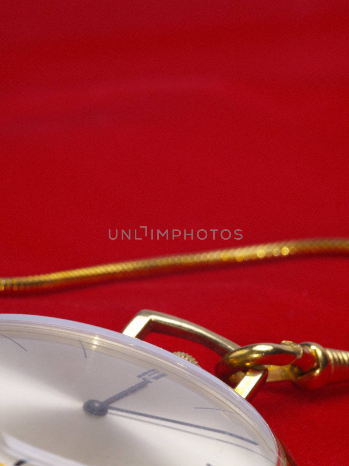 detail of gold pocket watch on red velvet