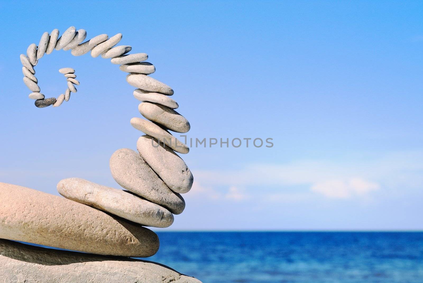 Sea pebble in the form of a spiral in the summer morning on a beach