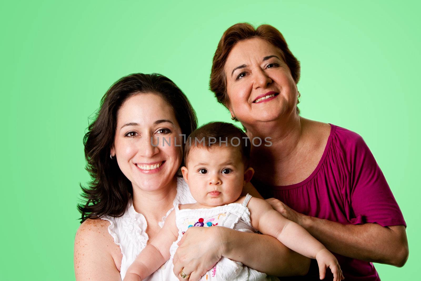 Beautiful happy three 3 generations of Caucasian Hispanic Latina women, grandmother, mother and baby girl, on green.