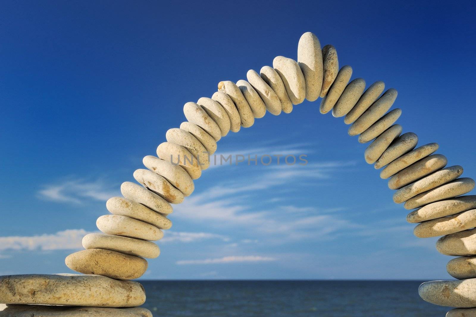 Sea pebble combined in an arch against the sky