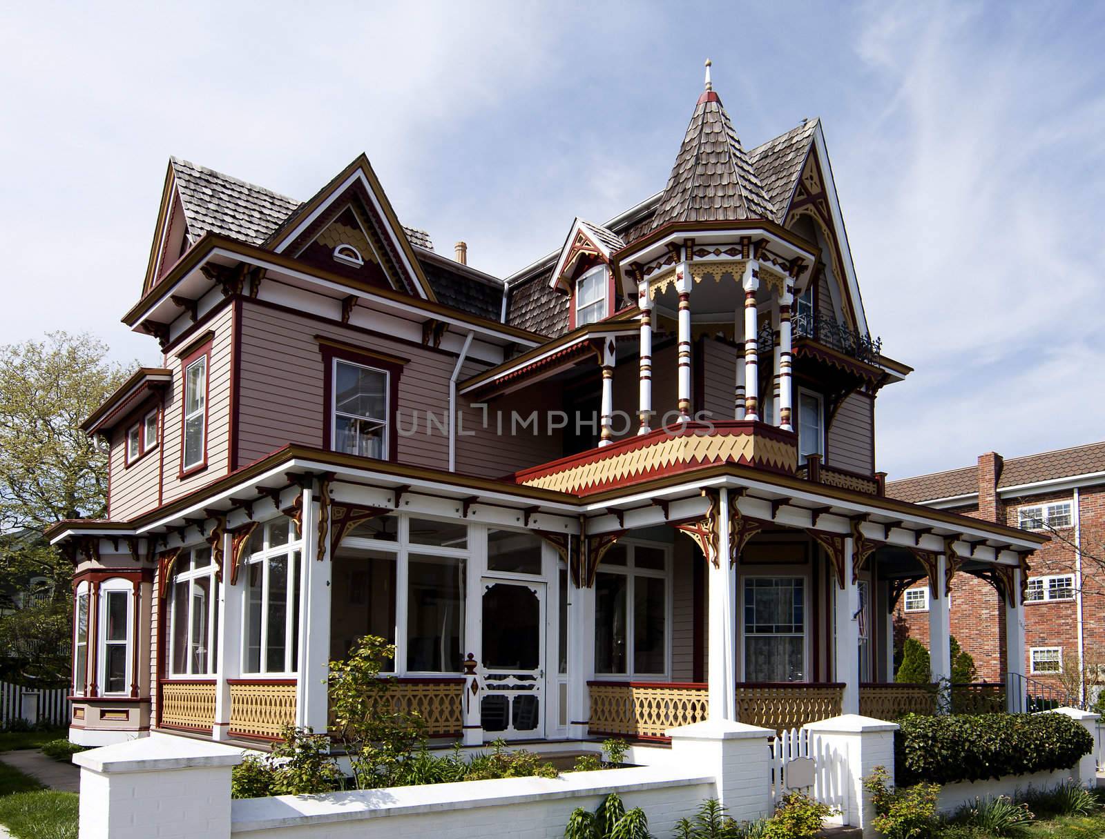 Beautiful colorful wooden Victorian style residential building with porch and balcony on a bright summer spring day.