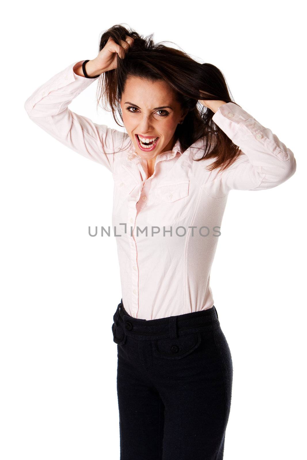 Beautiful stressed yelling successful Caucasian Hispanic entrepreneur business woman standing, wearing dark blue pants and pink shirt with hands pulling hair, isolated.