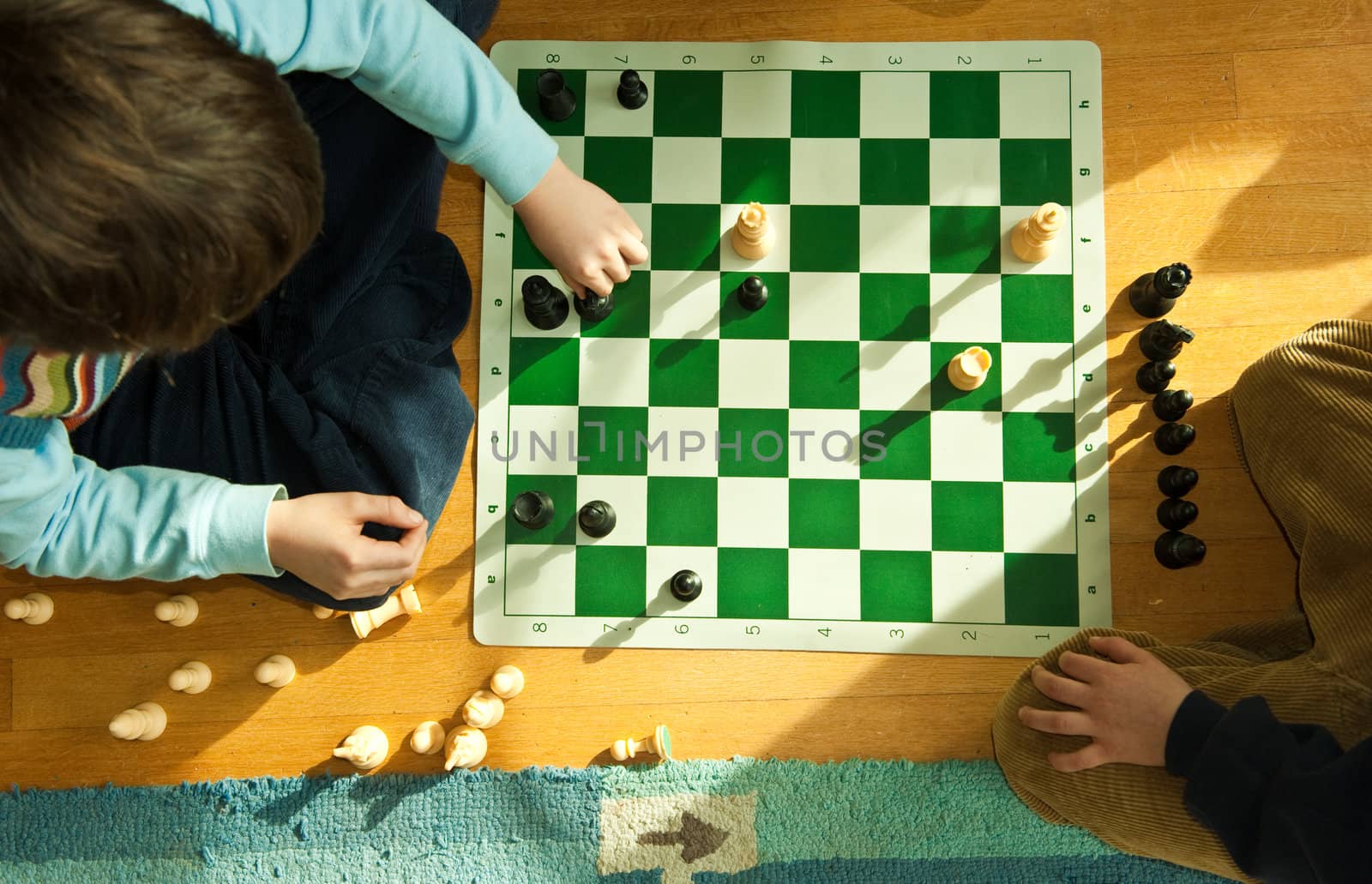 looking down on boy playing chess on floor