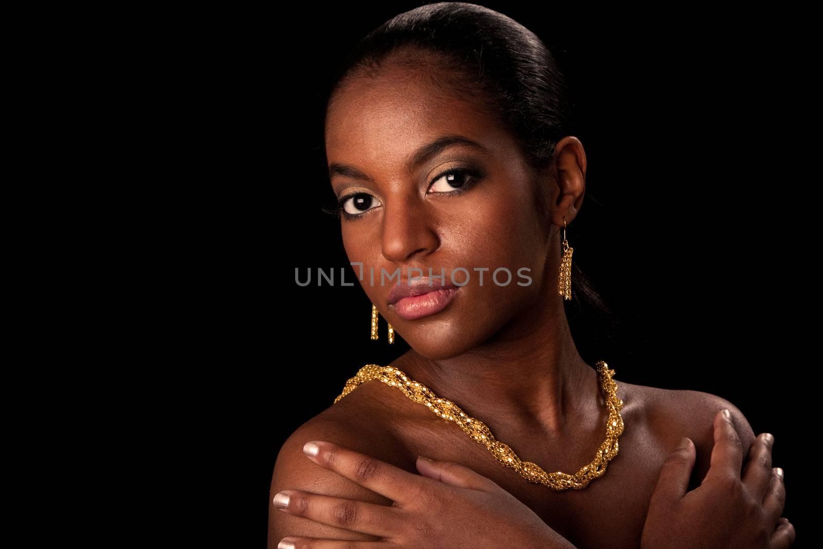 Face of beautiful African American woman with gold earrings and necklace, isolated.