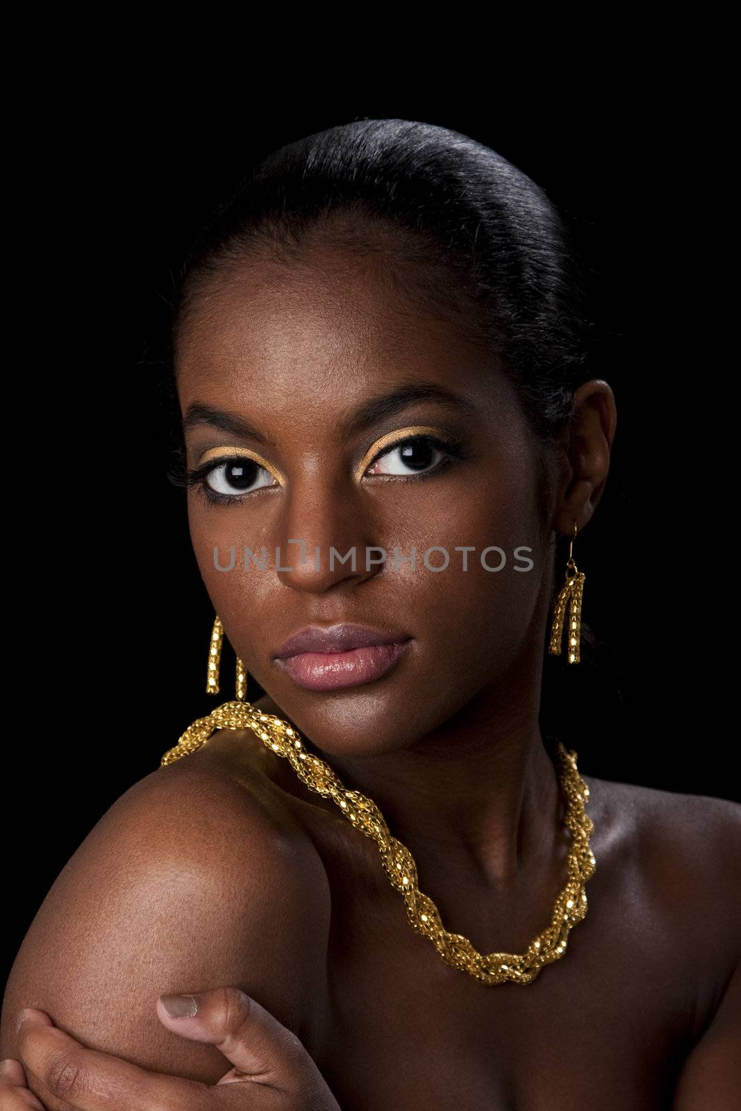 Face of beautiful African American woman with gold earrings and necklace, isolated.