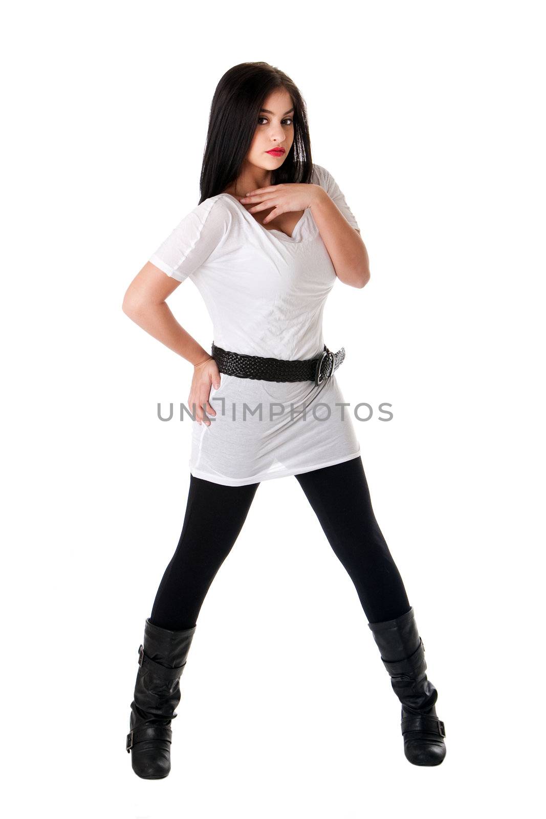 Beautiful brunette Caucasian Hispanic Latina woman with red lipstick standing with legs spread, wearing white shirt, black leggings and belt, isolated.