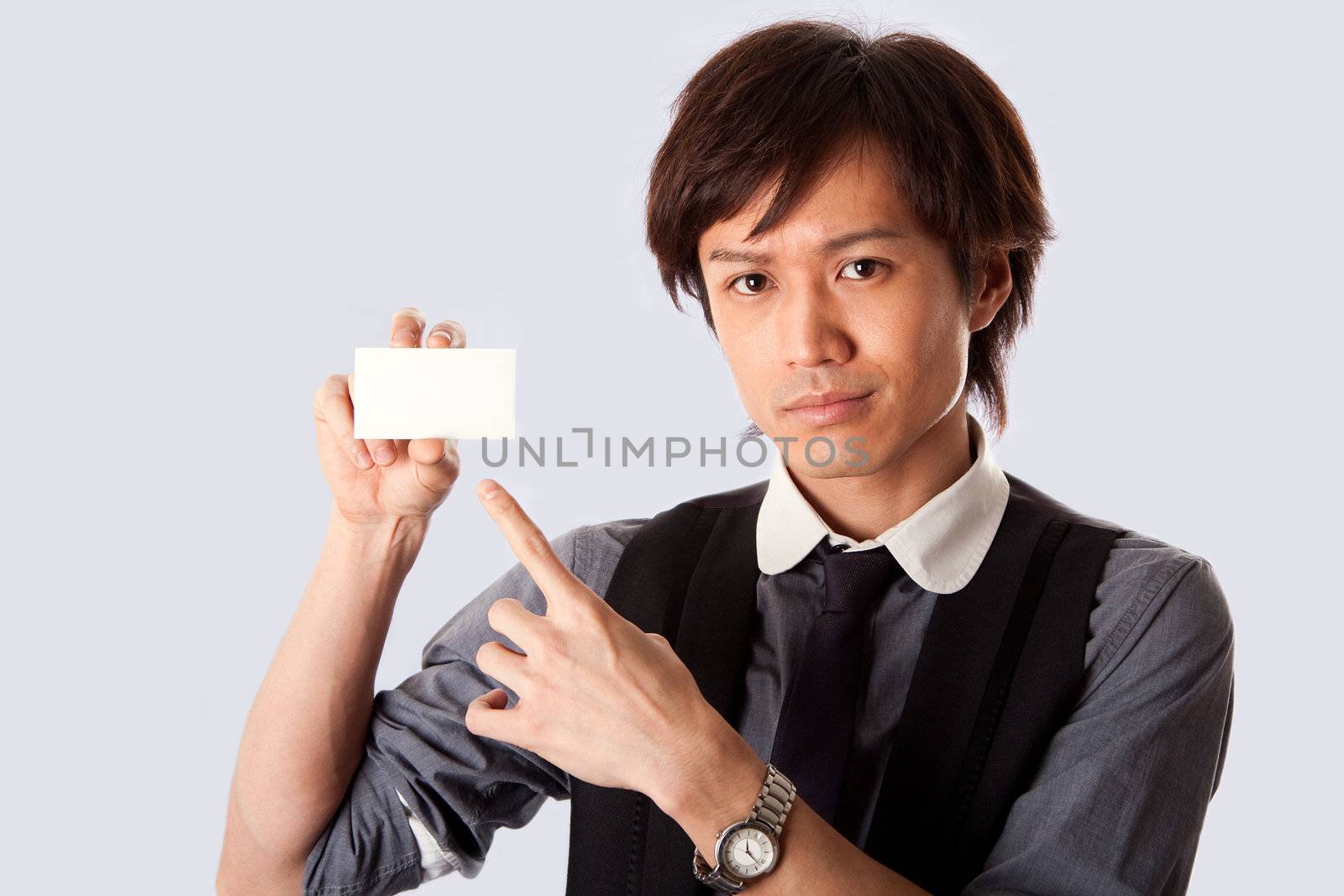 Asian business man holding and presenting a blank white card and pointing at it, isolated.