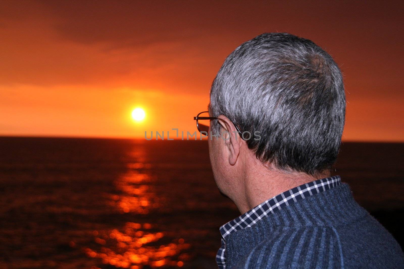 mature man watching sunset in the beach