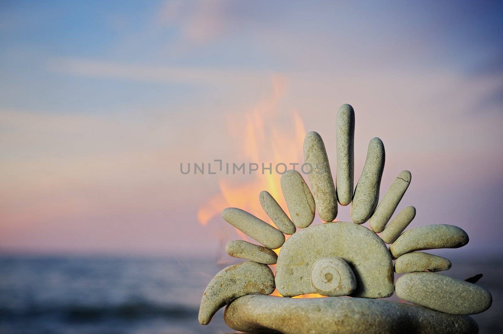 The stone sun burns on a beach in the summer evening