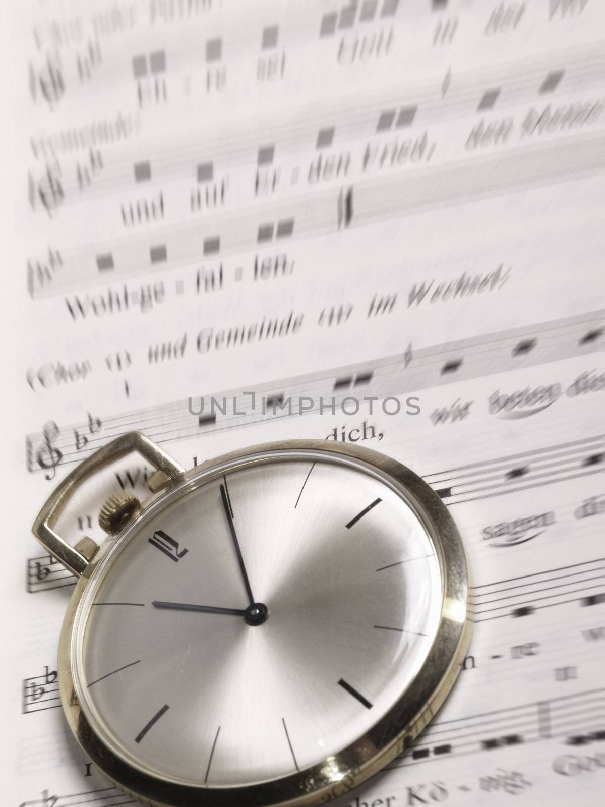 pocket watch over old sheet of music