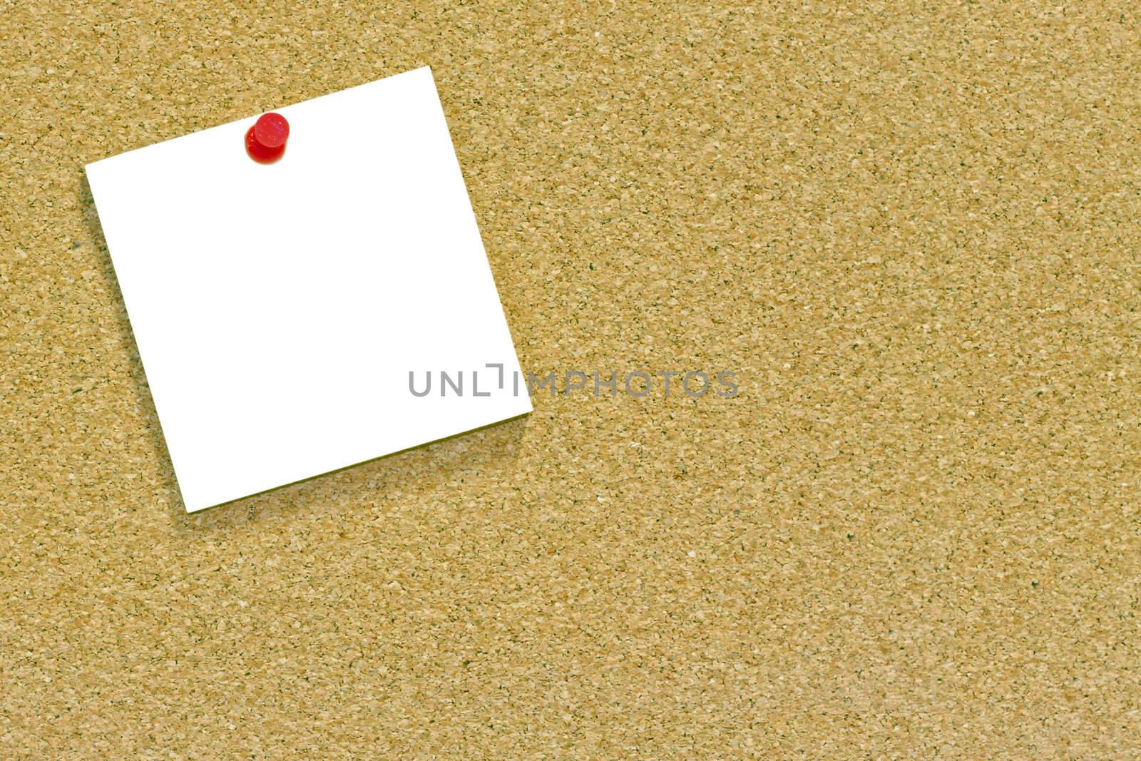 A blank memo or sticky note tacked to a cork notice board with copyspace. 