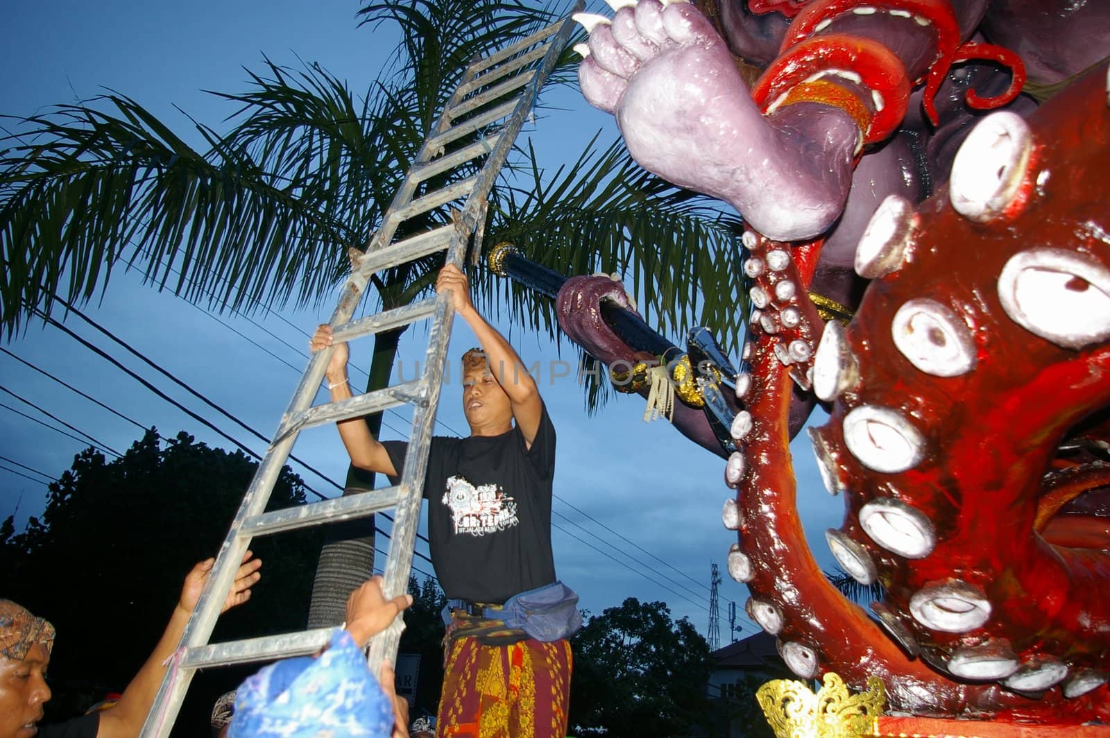 Setting up a ladder to climb a giant statue at the Balinese Hindu festival of Pengrupukan, in Nusa Dua, Bali, March 15, 2008. The annual festival is to roust out the devils which have gone into hiding on the island.