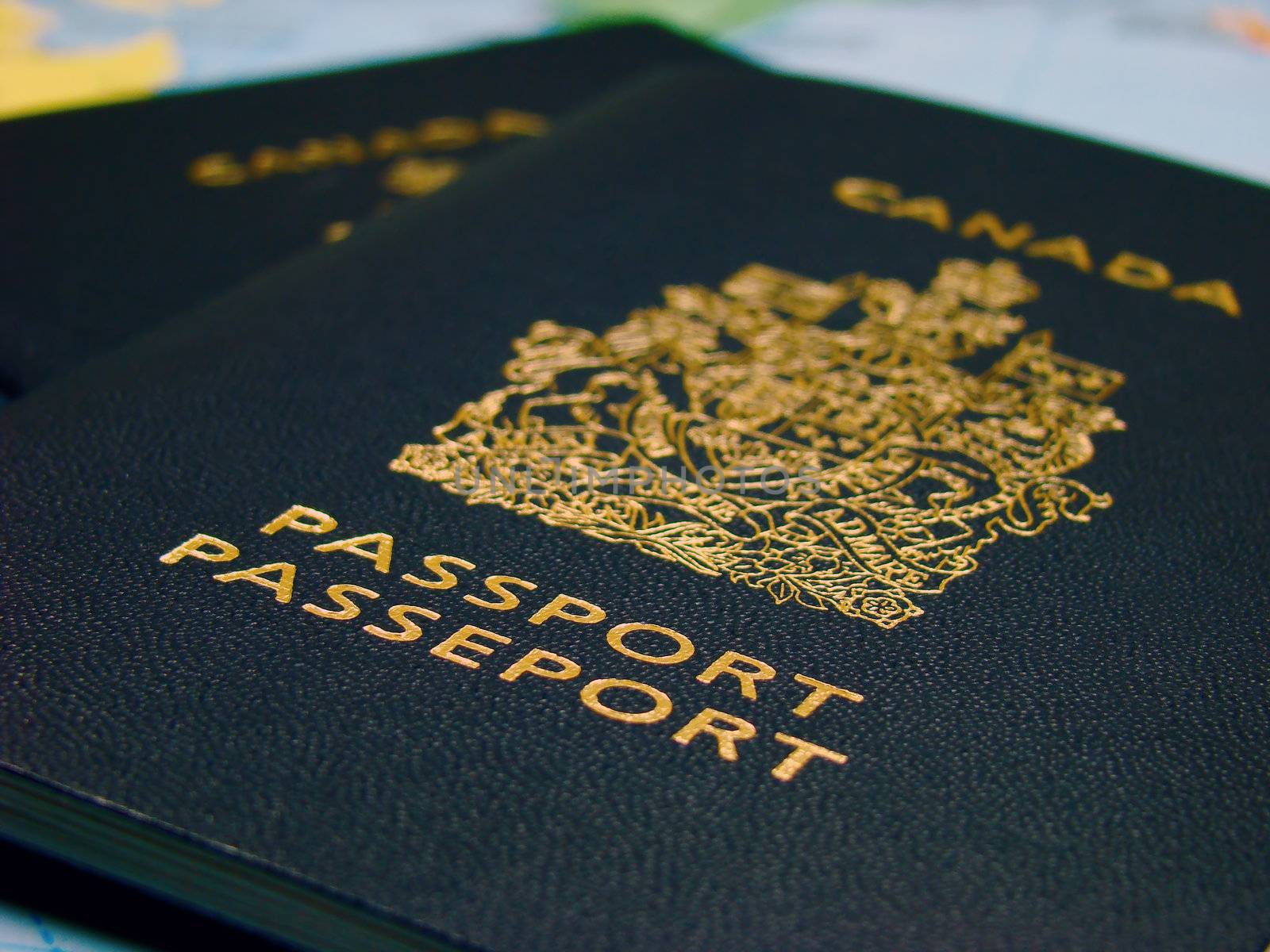 Two Canadian passports against map (bilingual English and French).