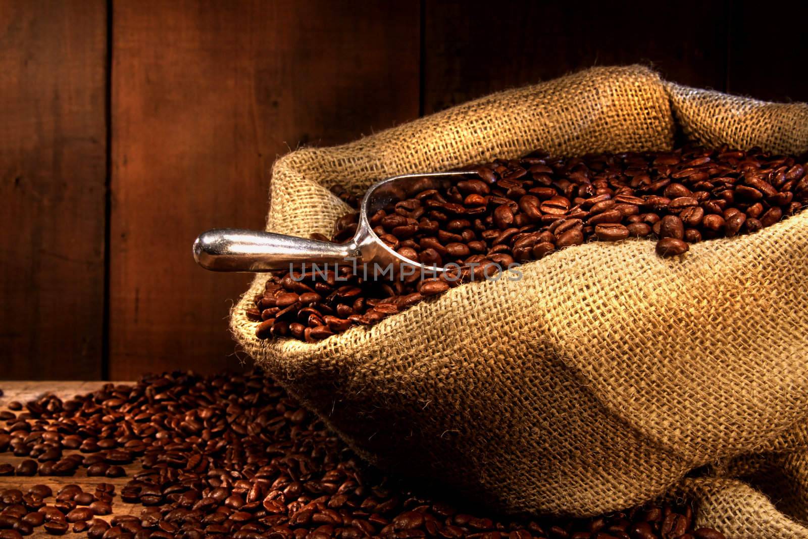 Coffee beans in burlap sack with antique wood background