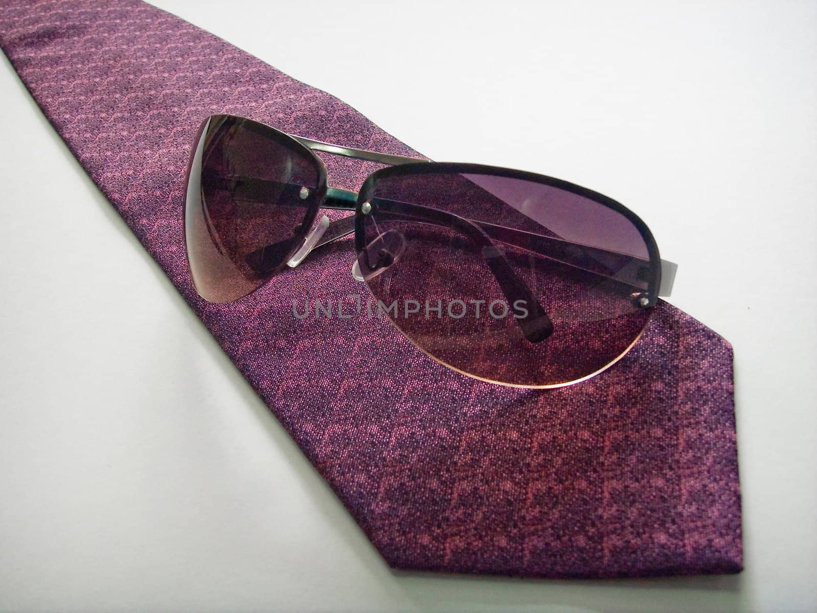 Purple sunglasses on purple businessman tie on a white background