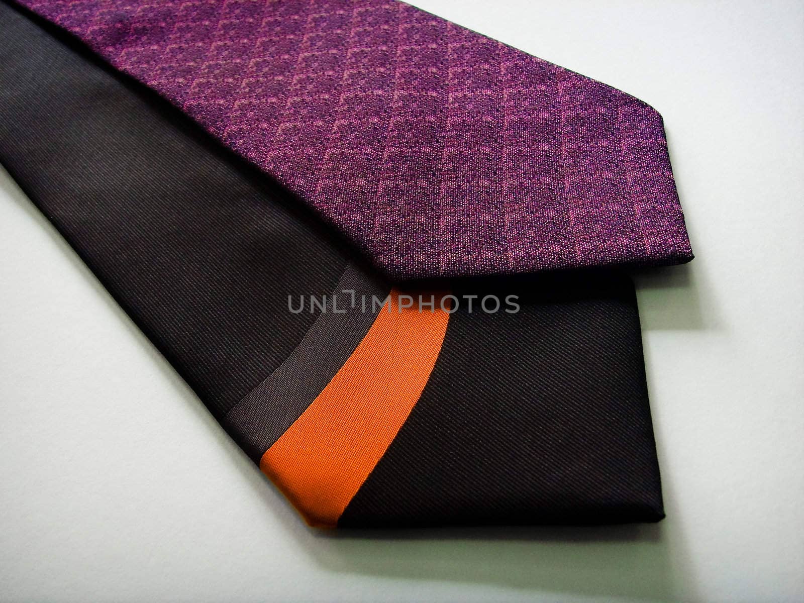 A black and a purple tie on a white background