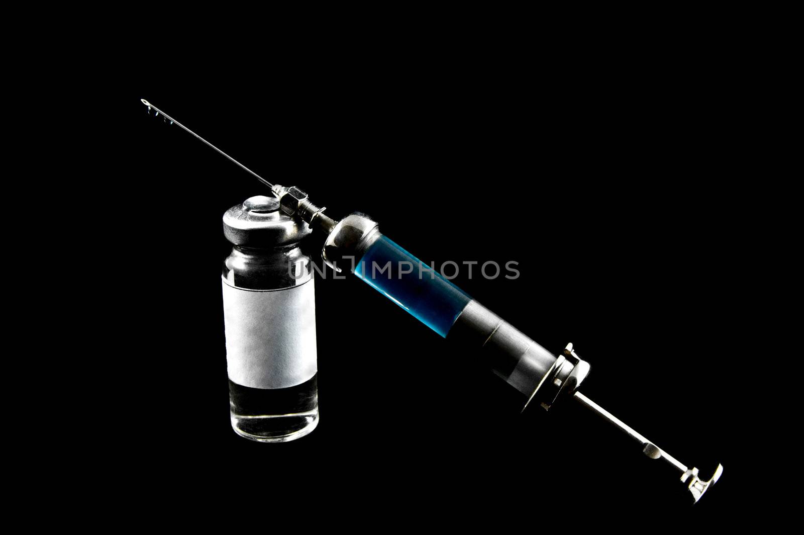 Reusable syringe and blue medicaments on a black background